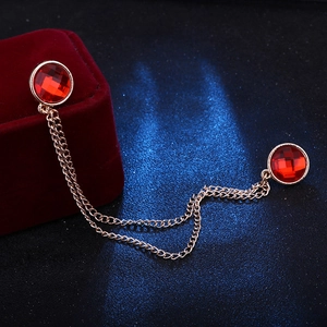 Detailed view of golden collar chain with red round gemstones and tassel on velvet