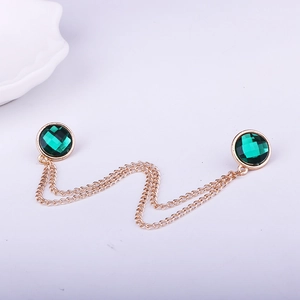 Detail of green crystal collar chain with double layered gold tassel and metal base