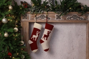 Close-up of knit Christmas stockings with reindeer patterns on a festive mantel