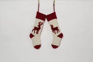 Detail of knitted Christmas stockings in cream and red featuring reindeer patterns