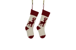 Detail of knitted Christmas stockings with red reindeer patterns on a white background