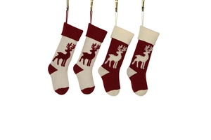 Close-up of four knitted Christmas stockings with reindeer patterns in red and off-white