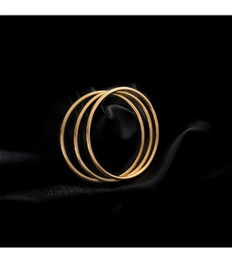 Detailed view of three minimalist polished gold bangles on a luxury black leather base