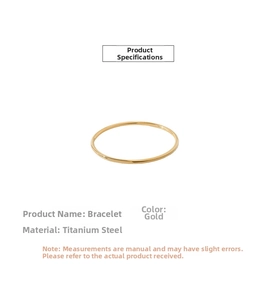 Detail of minimalist gold titanium steel bangle with polished finish and sleek circular design