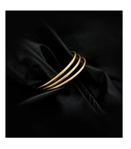 Minimalist polished gold stainless steel stackable bangles set of 3 on black background