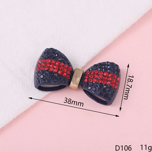 Detailed macro view of 38mm navy blue rhinestone bow with red stripes for DIY jewelry