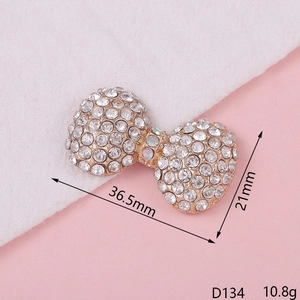 Close-up of golden bow tie charm with rhinestones measuring 36.5mm by 21mm size