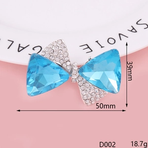 Blue gemstone bow brooch with rhinestones on pink background, size 39mm x 50mm