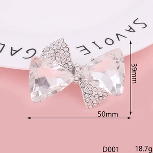 Macro shot of silver bow pendant with clear crystals and rhinestones, 50mm x 39mm size