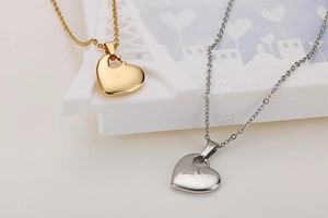 Close-up of gold and silver heart pendants on a white decorative display stand