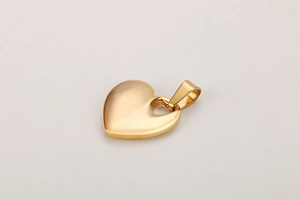 Close-up of minimalist heart pendant in gold finish showing smooth metallic texture