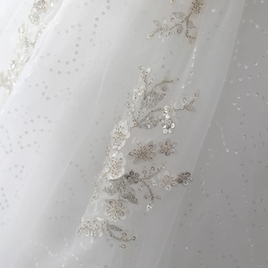 Robe mariée en dentelle avec broderie florale et sequins sur un tissu en tulle blanc