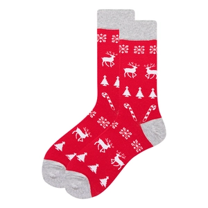 Gros plan de chaussettes de Noël rouges avec motifs de rennes, flocons et sucres d'orge