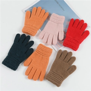 Flat lay view of six colorful knitted winter gloves for children on a white background