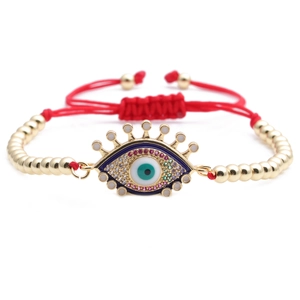 Detailed macro view of the adjustable red cord and enameled golden Evil Eye pendant