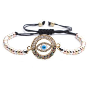 Macro detail of multi-color zircon evil eye pendant with tri-color metallic beads