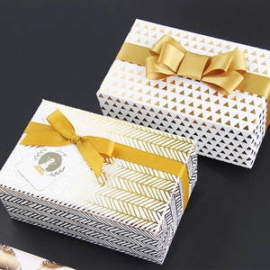 Gold foiled gift boxes with geometric patterns, satin bows and festive joy gift tags