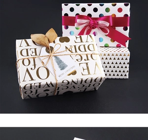 Elegant gift wrapping set with gold dots, ribbons, and holiday tags on dark background