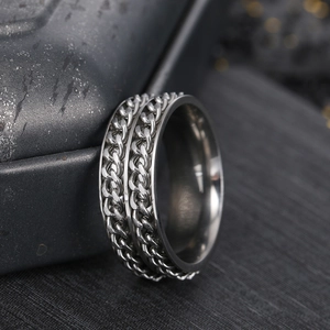 Macro view of silver titanium steel spinner ring with double chain design on dark stone