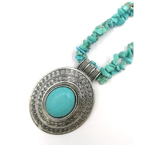Detail of vintage silver necklace featuring large oval turquoise stone and spiral patterns