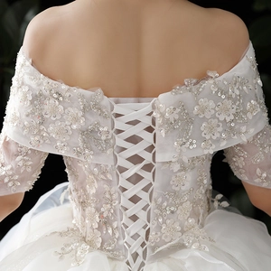 Elegant off-shoulder lace wedding dress with floral embroidery and corset back detail