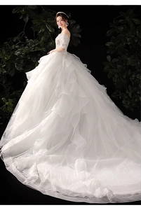 Detail of elegant off-shoulder lace bodice with intricate beadwork on white bridal gown