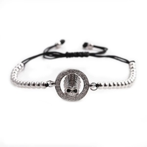 Macro detail of gothic skull bracelet featuring inlaid zircons and adjustable woven cord