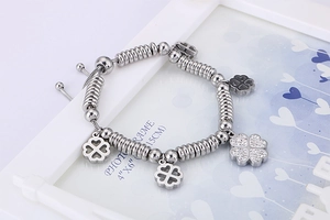 Detail of silver clover bracelet with sparkling white zircon charms on beads chain