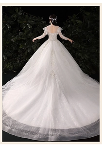Vue arrière spectaculaire d'une robe de mariée en dentelle blanche avec traîne et sequins