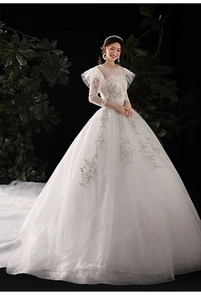 Détails des manches en dentelle blanche et corsage à paillettes avec broderies florales