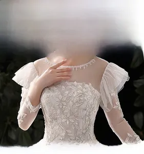 Détail d'une robe de mariée avec broderie florale 3D et épaules en tulle à volants