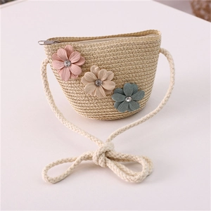 Close-up of summer straw bag for girls with 3D fabric flowers and secure metal zipper