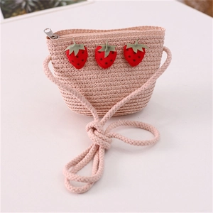 Detail of pink straw crossbody bag for kids featuring cute red strawberry patches
