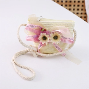 Detail of straw woven crossbody bag with pink ribbon and yellow sunflower decorations