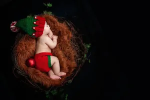 Detail of newborn baby Christmas photography outfit with hand-knitted long tail hat and shorts