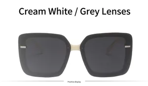 Detail view of square frame sunglasses with cream white bridge and dark grey lenses