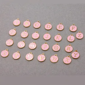 Macro shot of 26-piece set of pink enamel A-Z alphabet charms with gold plating