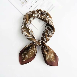 Close-up of brown paisley print satin square scarf with a smooth silk texture