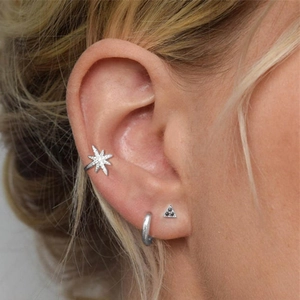 Macro shot of S925 sterling silver star ear cuff and triangle stud earring set
