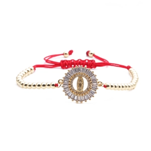 Braided red rope bracelet with gold beads and Virgin Mary sunburst medallion charm
