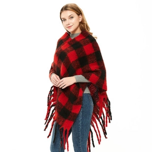 Close-up of red and black checkered knit poncho featuring decorative long fringe edges