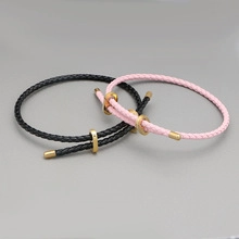 Detail of adjustable woven couple bracelets with magnetic heart and golden metal tips