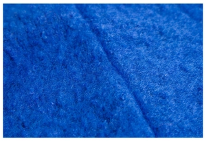 Macro shot of deep blue boucle yarn texture and stitched seam detail on the winter shawl