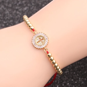 Goldenes Perlenarmband mit Zirkonia-Kreuzanhänger an einem Handgelenk getragen