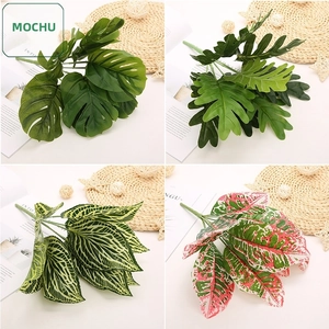 Detail showing artificial monstera and philodendron leaves with realistic silk textures