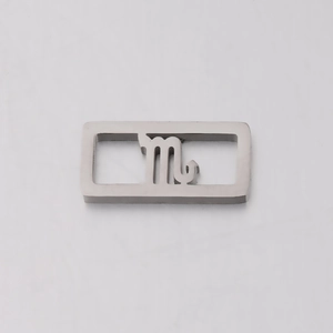 Macro detail of a silver stainless steel rectangular Scorpio zodiac charm for DIY jewelry