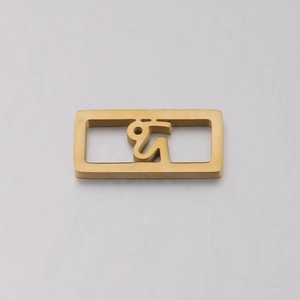 Close-up of golden hollow square zodiac charm pendant with abstract symbol engraving