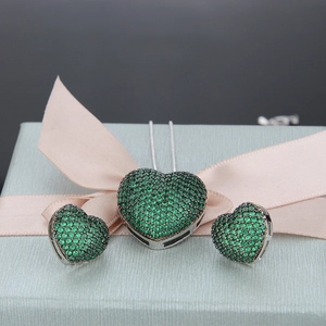 Detailed shot of green heart-shaped jewelry set with necklace and earrings in a gift box