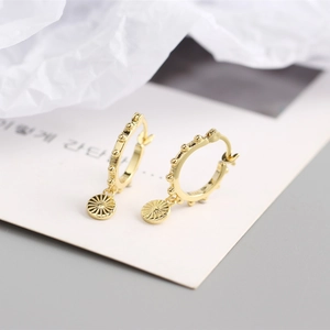 Détail de créoles en argent S925 doré avec petites perles et pendentif tournesol