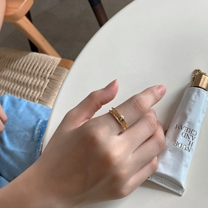 Detail shot of a minimalist double-layered gold ring with diamond-shaped accents